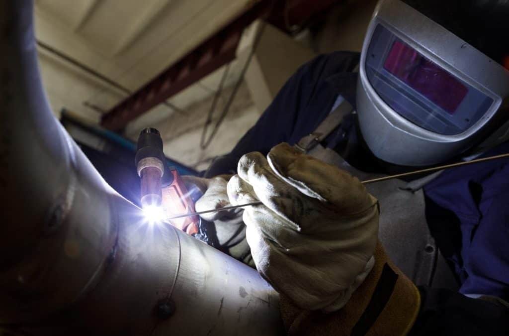 A welder performing either MIG or TIG stainless steel (hexavalent chromium) welding on a pipe
